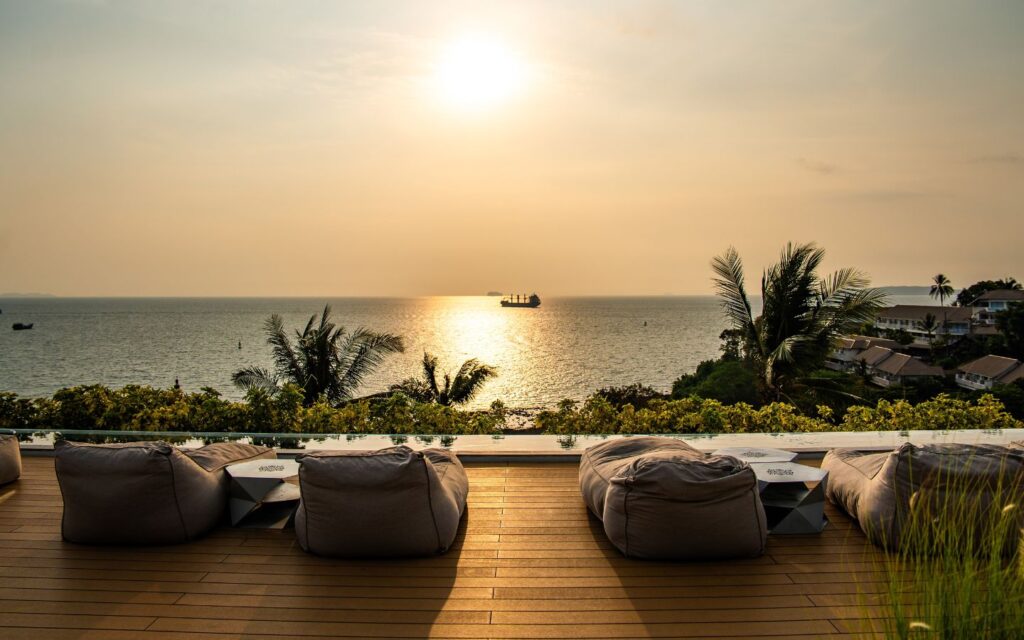 Oceanfront view with loungers and calm waters at a relaxing hotel.