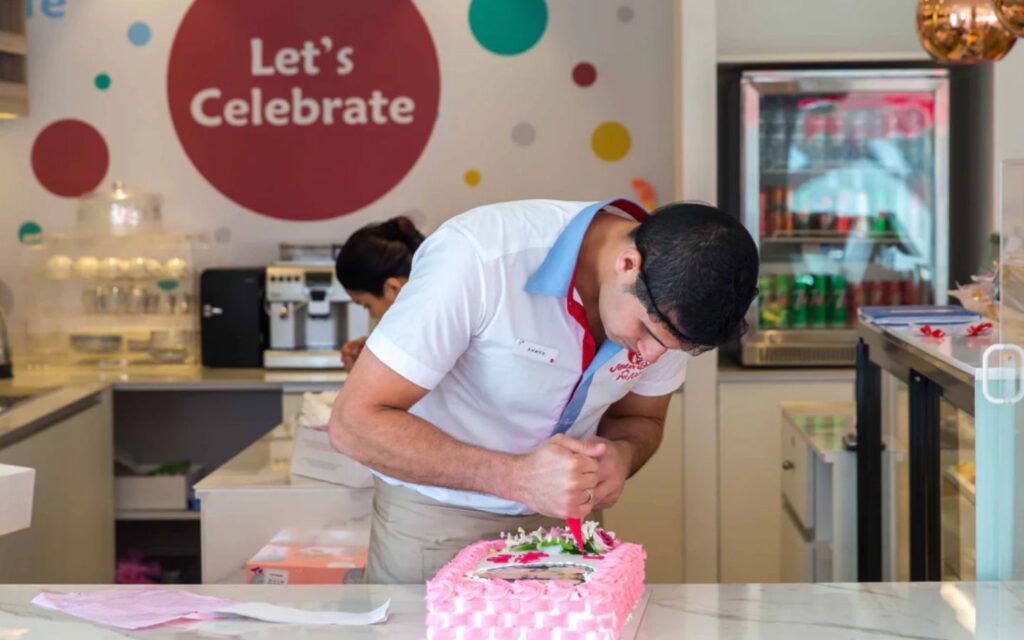 a staff member customizing the cake