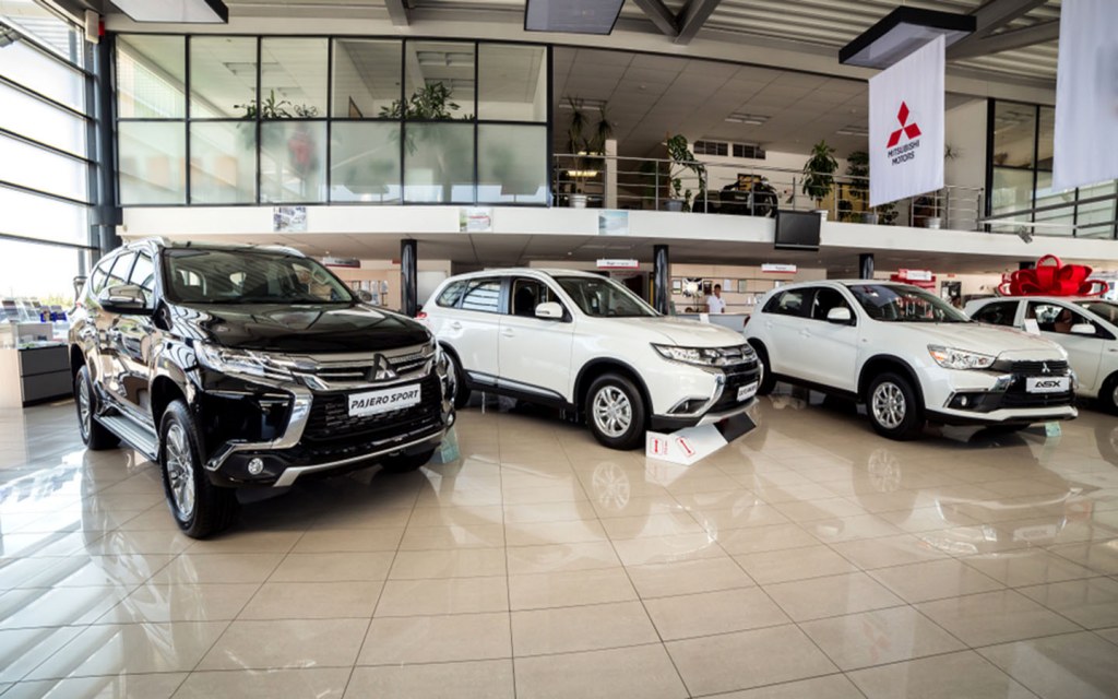 New Mitsubishi SUVs displayed in a bright, modern car showroom.