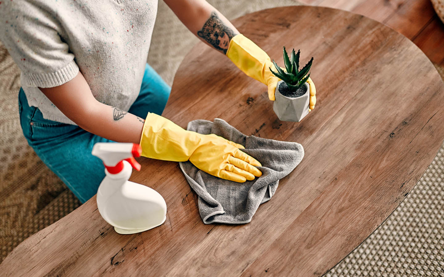 سيدة تنظف طاولة خشبية