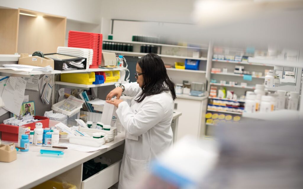 a staff stocking medicines in a pharmacy