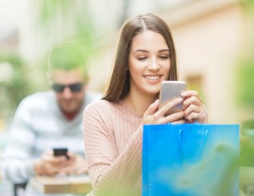 woman with a shopping bag, using her phone