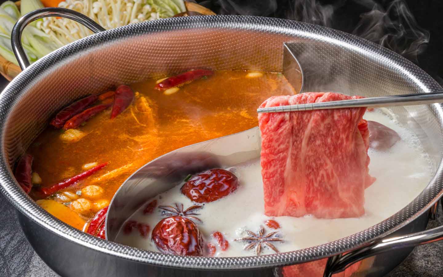Chinese hot pot being prepared with herbs
