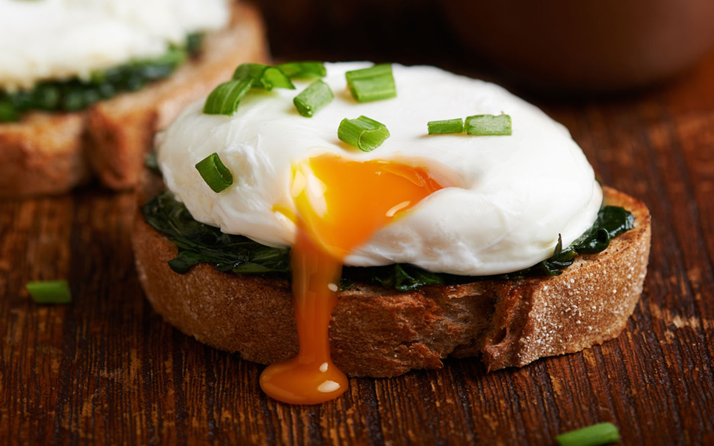 Poached egg a top spinach on a wooden table