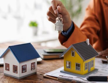 Real estate professional comparing property models and documents