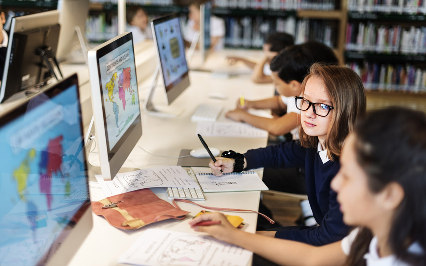 طلاب مدرسة يدرسون على أجهزة الكمبيوتر