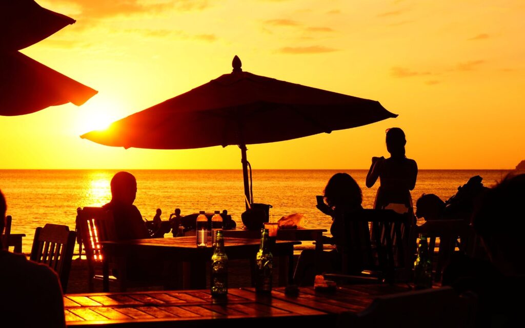 Guests enjoying a sunset dinner by the beach at an Abu Dhabi resort.