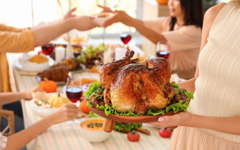 A festive Thanksgiving spread in Dubai featuring a golden roast turkey, sides and desserts ready for take-away.