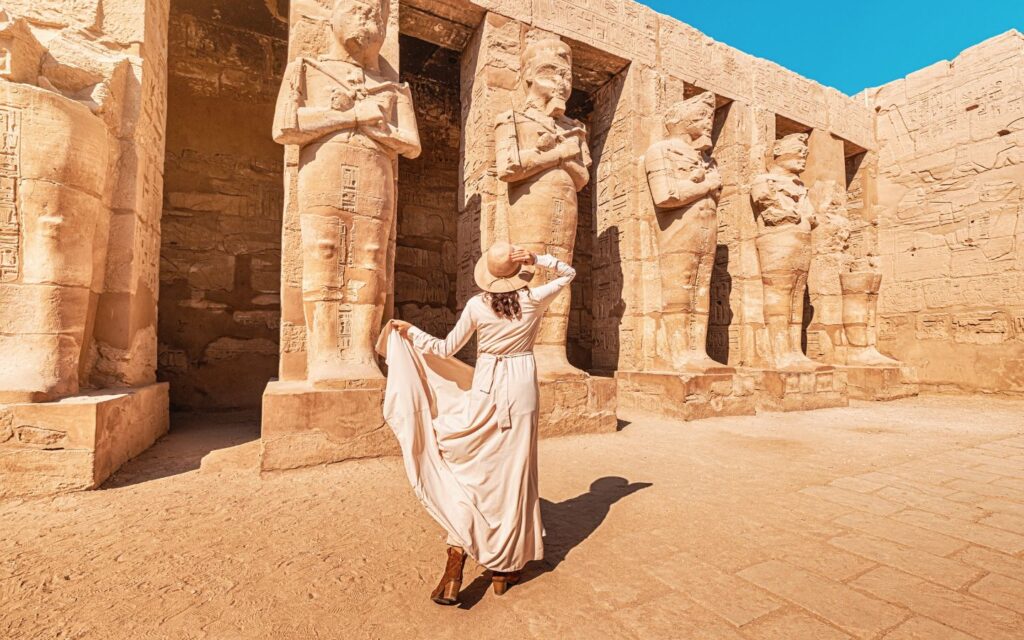 Travellers exploring cultural landmarks with desert dunes stretching into horizon.